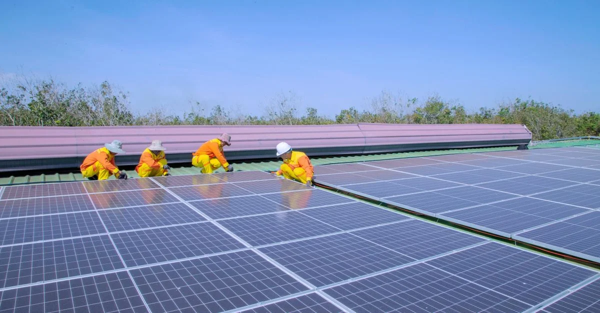 Des travailleurs installent des panneaux solaires par une journée ensoleillée, promouvant les énergies renouvelables et la durabilité.